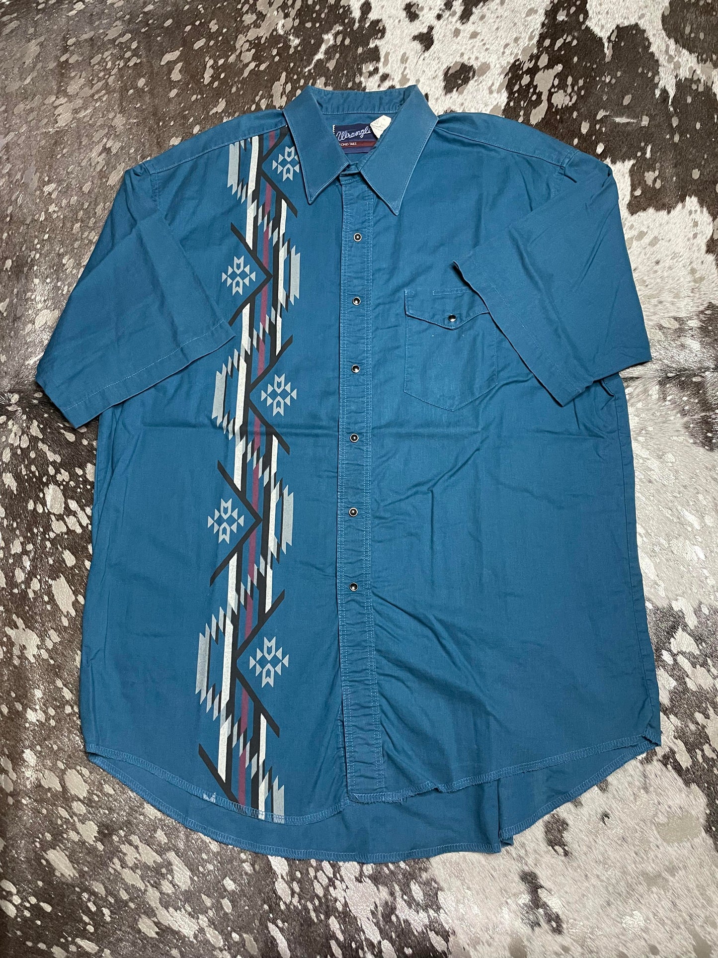 Teal short sleeve button up with aztec details in singular stripe down right side.